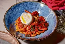  ?? ?? Hand-rolled thick noodles called pici anchor a dish that also features burrata, tomato butter sauce, olive oil and basil.