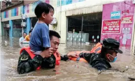  ?? Photograph: CNS/AFP/Getty Images ?? Rescuers evacuate a child from a flooded area after heavy rains in Suizhou, in China’s central Hubei province.