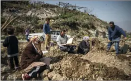  ?? SERGEY PONOMAREV — THE NEW YORK TIMES ?? A gathering is held to pay respects to four family members recently buried at a cemetery in Atakya, Turkey, on March 3.