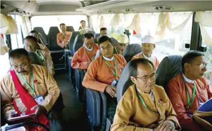  ??  ?? NAYPYIDAW: In this photo taken on January 30, 2016, newly-elected National League of Democracy (NLD) members of parliament sit in a bus as they depart the city developmen­t committee compounds for parliament. — AFP