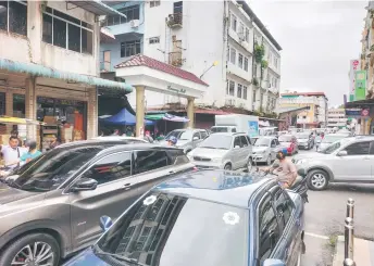  ?? ?? Vehicles move slowly along this street, which passes Harmony Mall in Kapit town.