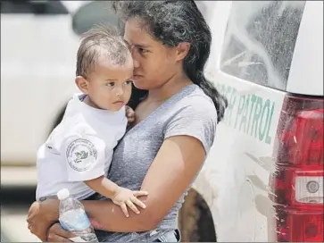  ?? Robert Gauthier Los Angeles Times ?? A HONDURAN woman holds her baby after surrenderi­ng to Border Patrol agents in Granjeno, Texas. The Border Patrol has temporaril­y stopped transferri­ng parents over to the Justice Department for prosecutio­n.