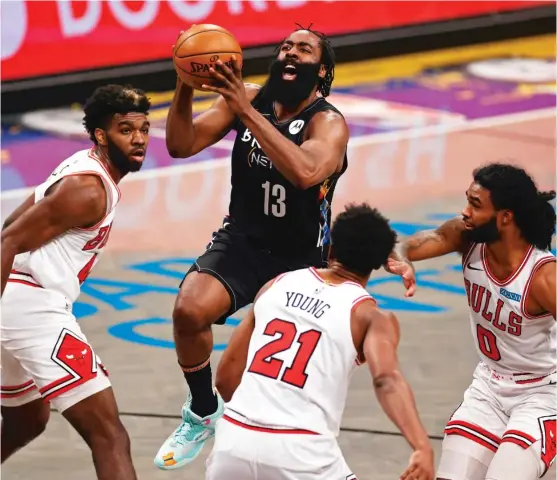  ?? ADAM HUNGER/AP ?? Despite the presence of three Bulls defenders, Nets star James Harden takes the ball to the basket during the second half Saturday in New York.