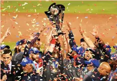  ?? (Reuters) ?? TEAM USA players hold up the championsh­ip trophy after defeating Puerto Rico 8-0 in yesterday’s final of the 2017 World Baseball Classic at Dodger Stadium.