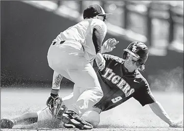  ?? AP/BRENDAN SULLIVAN ?? (left) tags out LSU’s Zach Watson during the sixth inning of Friday’s game. The Tigers beat the Beavers 3-1 to put an end to their 23-game winning streak. LSU also avenged Monday’s 13-1 loss to Oregon State.