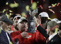  ?? The Associated Press ?? Chris O’Meara
Chiefs chairman Clark Hunt hands the Lombardi Trophy to coach Andy Reid after the Chiefs’ 31-20 victory over the San Francisco 49ers in the Super Bowl in February.