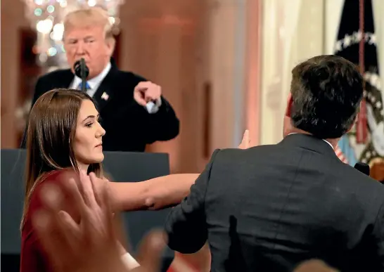  ?? AP ?? CNN’s Jim Acosta leans away as a White House aide tries to take the microphone from him during a news conference in the East Room of the White House.