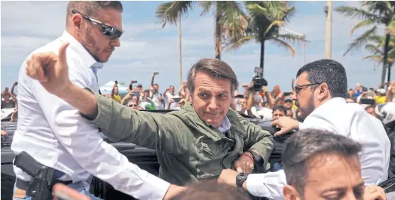  ?? RICARDO MORAES/REutERS ?? Bolsonaro votó ayer en Río rodeado de seguidores y de guardaespa­ldas