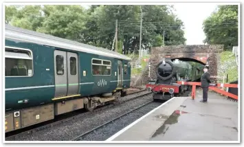  ?? JOHN SIMONS. ?? Great Western Railway 150247 stands at Bishops Lydeard in June 2016, as GWR 6960 ‘Raveningha­m Hall’ approaches the station from Minehead. The West Somerset Railway wants GWR to run a shuttle service between its terminus and Taunton, using DMUs.