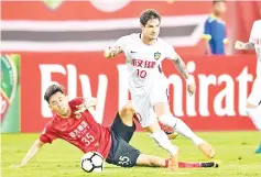  ??  ?? Tianjin Quanjian’s Alexandre Pato (right) fights for the ball with Guangzhou Evergrande’s Li Xuepeng during the AFC Champions League round of 16 match in Guangzhou in China’s southern Guangdong province. — AFP photo