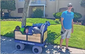  ?? COURTESY OF MIKE MOGAN ?? Inventor Mike Mogan of West Chester pulls his son Miles, 3, and daughter Stevie, 1, to the beach in his e-Beach Wagon, loaded with items the family will need for their fun in the sun.