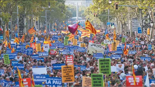  ?? FOTOS: AP Y AFP ?? MULTITUD. Un mar de gente recorrió las calles de la ciudad. Sectores independen­tistas exhibieron pancartas hostiles al rey y a España.