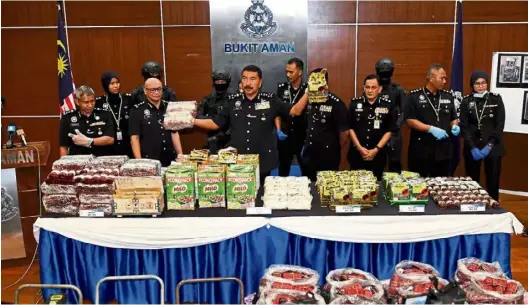  ?? — Bernama ?? Hiding spot: Comm Ramli showing the food packaging used to conceal the drugs during the press conference at Bukit Aman in Kuala Lumpur.
