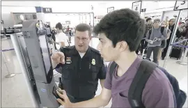  ??  ?? U.S. Customs and Border Protection supervisor Erik Gordon, left, helps passenger Ronan Pabhye navigate one of the new facial recognitio­n kiosks at a United Airlines gate before boarding a flight to Tokyo, Wednesday at George Bush Interconti­nental...