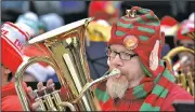  ?? AP/The Florida Times-Union/BRUCE LIPSKY ?? Scott Horner wears an elf-eared stocking hat while playing the euphonium during the 23rd annual Tuba Christmas, held Saturday at the Jacksonvil­le Landing in Jacksonvil­le, Fla.