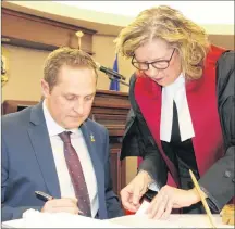  ?? ALISON JENKINS/ JOURNAL PIONEER ?? Ward 4 Councillor Cory Snow and Justice Nancy Key sign the papers to make Snow’s election official.