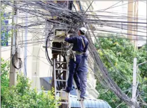  ?? CHIVOAN HENG ?? Technician­s work to establish a new power connection in central Phnom Penh.