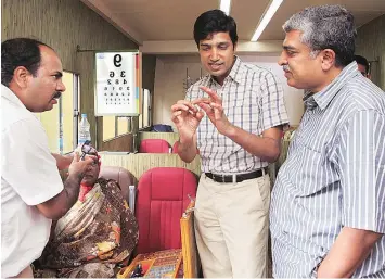  ??  ?? Drishti founder and CEO Kiran Anandampil­lai (centre) and Nandan Nilekani (right) with a patient inside their mobile van