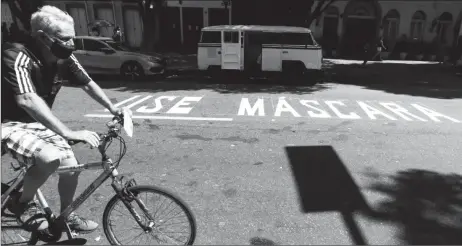  ??  ?? A man rides a bicycle next to a message reading “Use mask” painted on the street, following the coronaviru­s disease (COVID-19) outbreak, in Rio de Janeiro, Brazil April 30, 2020. REUTERS/Pilar Olivares