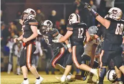  ?? STAFF PHOTO BY ROBIN RUDD ?? Meigs County’s defense celebrates a South Greene turnover Friday night.