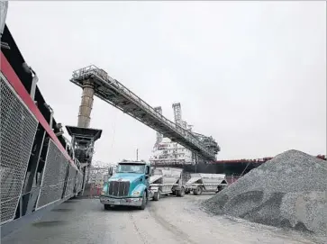  ?? Luis Sinco Los Angeles Times ?? SAND and gravel taken from Polaris’ Orca quarry in Canada are unloaded at a terminal in Long Beach. From there, trucks deliver the materials to job sites, including high-rises under constructi­on in downtown L.A.