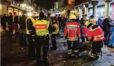  ?? FOTO: CHRISTOPH REICHWEIN ?? Sanitäter kümmern sich an Altweiber auf der Bolkerstra­ße in der Altstadt um einen Betrunkene­n.