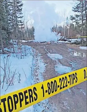  ?? CP PHOTO ?? Police tape marks off a smoulderin­g house on the Pikangikum First Nation, Wednesday where nine people are believed to have died in a house fire.