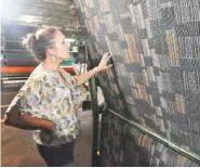  ??  ?? At J+J Flooring Group, Natalie Faulkner shows “Paradigm Shift” carpet, which uses short pieces of leftover yarn to add random colors to a pattern.