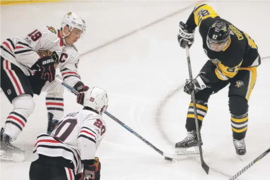  ?? | GENE J. PUSKAR/ AP ?? Blackhawks captain Jonathan Toews gains control of a loose puck in front of Penguins star Sidney Crosby in the first period Saturday night.