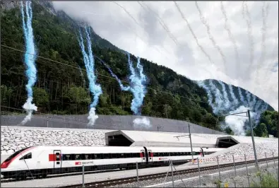  ?? AP/LAURENT GILLIERON ?? The first train to exit the Gotthard rail tunnel’s north portal near Erstfeld, Switzerlan­d, is greeted with a fireworks display Wednesday.