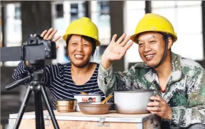  ?? ?? He and Tang wave to camera as they finish recording a video clip of their lunch on April 29.