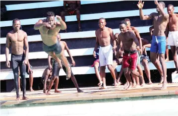  ??  ?? COOLING OFF . . . Boys dive into Les Brown Swimming Pool to beat hot summer temperatur­es in Harare yesterday . — Picture: John Manzongo