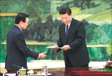  ?? XU JINGXING / CHINA DAILY ?? The Republic of Korea’s special envoy Lee Hae-chan (left) presents a handwritte­n letter from ROK President Moon Jae-in to President Xi Jinping during a meeting at the Great Hall of the People in Beijing on Friday.