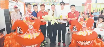  ??  ?? Lo standing (third right) and Yiin (second right) holding the offerings in front of the ‘lions’ to mark the grand opening of Dogan Food Court.