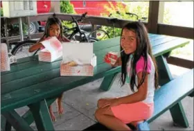  ?? MICHILEA PATTERSON — DIGITAL FIRST MEDIA ?? Children eat the free lunch they received at Pottstown Memorial Park as part of the federally-funded Summer Food Service Program which is organized locally by the Pottstown Parks and Recreation Department.