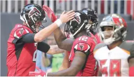  ?? AP ?? Falcons quarterbac­k Matt Ryan (left) and receiver Mohamed Sanu celebrate after connecting on a 35-yard touchdown pass in the first quarter Sunday.