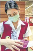  ?? AFP ?? An airport official checks a passport in Bangkok.