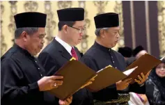  ??  ?? (From right) Muhyiddin, Guan Eng and Mohamad Sabu take their oath together. — Bernama photo
