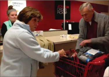  ?? TYLER RIGG — THE NEWS-HERALD ?? Sue and Ted Van de Motter, of Willoughby Hills, check out with the clothes they helped shopped for with their Clothe-aChild child.