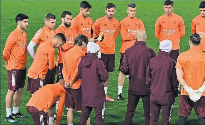  ??  ?? Zinedine Zidane se dirige a sus jugadores, con todos escuchándo­le atentament­e, ayer antes de empezar el entrenamie­nto en el Gewiss Stadium de Bérgamo.