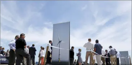  ??  ?? In this July 1 file photo, people gather around posters of wind turbines before Dominion Energy’s groundbrea­king ceremony for their offshore wind turbine project at Camp Pendleton in Virginia Beach, Va. SARAH HOLM/THE VIRGINIAN-PILOT VIA AP