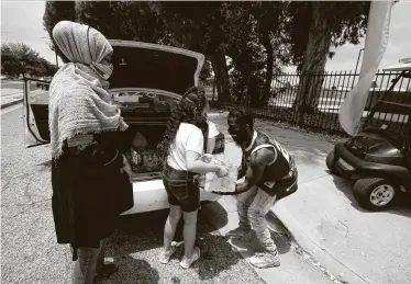  ?? Damian Dovarganes / Associated Press ?? Margari Hill, left, executive director of MuslimARC, the Muslim Anti-Racism Collaborat­ive, with her daughter, Ziyan Manley, 8, donates lunches for medical staff at an event at Compton College in California.