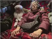  ?? ?? Santa and Mrs. Claus rest on the plane trip to Nuiqsut, Alaska, on Nov. 29.