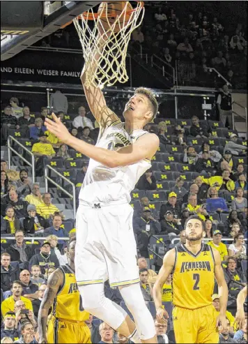  ?? TONY DING / AP ?? Michigan’s 6-11 sophomore Moe Wagner, who is from Germany, goes up for a layup in the first half, one of 7 of 8 shots he made against Kennesaw State on Saturday.