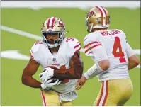  ??  ?? San Francisco 49ers quarterbac­k Nick Mullens hands off to Raheem Mostert during the second half against the Los Angeles Rams at SoFi Stadium on Sunday.