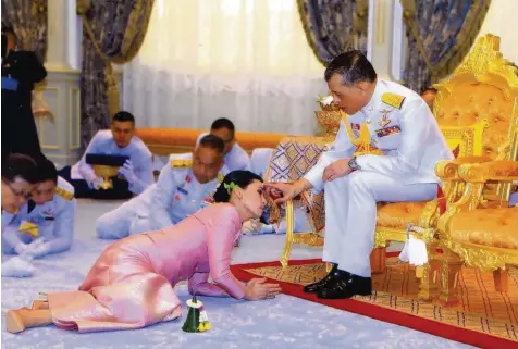  ?? Foto: Thai Royal Household Bureau, afp ?? Szenen einer Ehe: Bei der Trauungsze­remonie musste sich die neue Königin Suthida vor König Rama X. auf den Boden werfen.