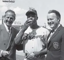  ?? Gene Smith, Associated Press file ?? Atlanta Braves’ Hank Aaron, center, poses for photos after getting his 3,000th career hit against the Cincinnati Reds on May 17, 1970. At left is Hall of Famer Stan Musial who was the last man to accomplish the feat, hitting his 3,000th in 1958. At right is Bill Bartholoma­y, owner of the Braves.