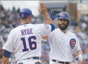  ?? The Associated Press ?? HELPING HIS CAUSE: First-base coach Brandon Hyde greets Jake Arrieta at first after the Cubs starting pitcher singles off Mike Leake in the first inning Friday at Chicago’s Wrigley Field. Arrieta notched his 18th victory, and the Cubs’ 98th, as Chicago...