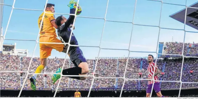  ?? FOTOS: ANDRÉU DALMAU / EFE ?? Imagen de Oblak atrapando un balón que intentaba rematar Lewandowsk­i desde una curiosa perspectiv­a desde detrás de la portería.