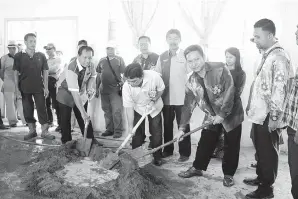  ??  ?? MUSBAH (tengah) mengambil bahagian membancuh simen semasa gotog royong. Turut kelihatan dalam gambar ialah Guru Besar SK Rosok, Mohd Taufik Abdullah (dua dari kiri).